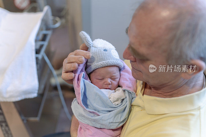 祖父第一次抱着孙子在病房里