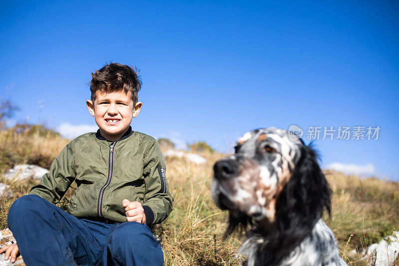 一个快乐的男孩和他的狗在山里