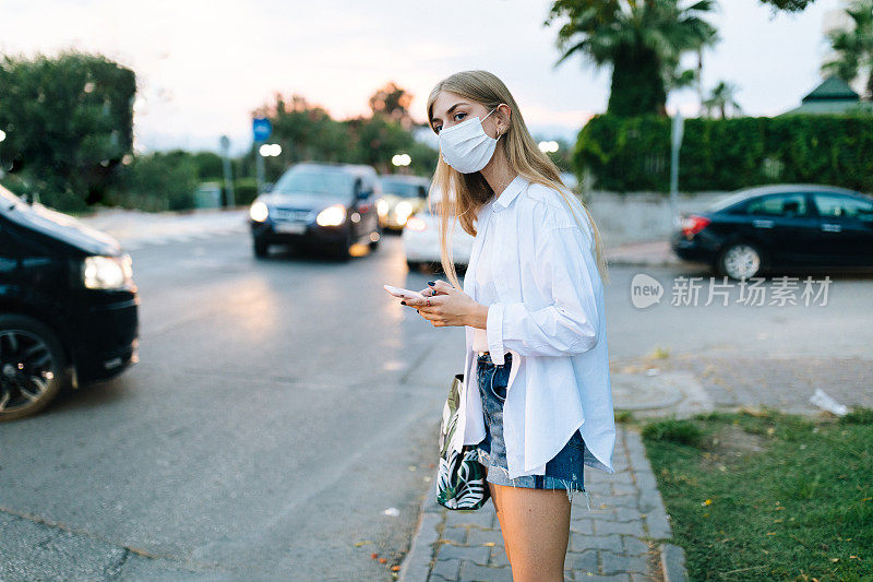 年轻的金发女人在等出租车