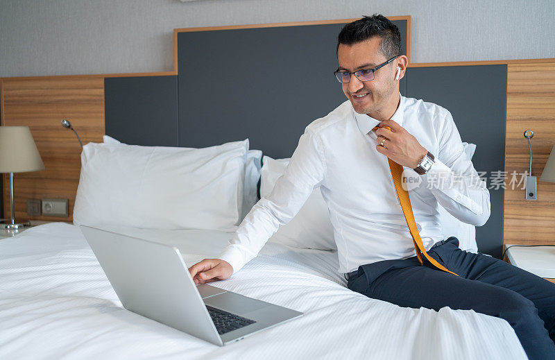 商人在床上使用笔记本电脑İn酒店房间