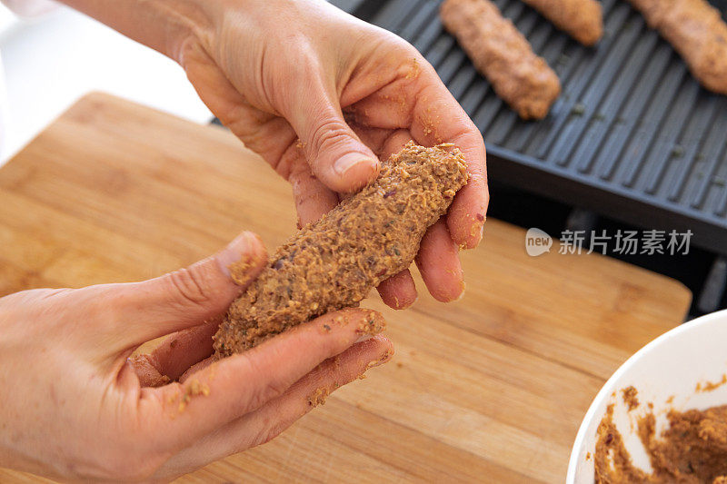 年轻女子为早餐准备素食香肠