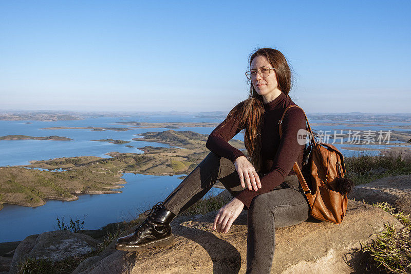 鹰山顶上的年轻女子。背景是巴西巴拉那的Itararé河