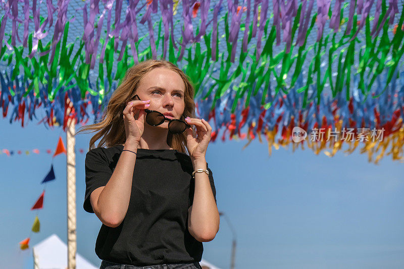 节日里的年轻女子。z一代的女孩喜欢户外，表达积极的情绪，在公园里玩。千禧世代的生活方式