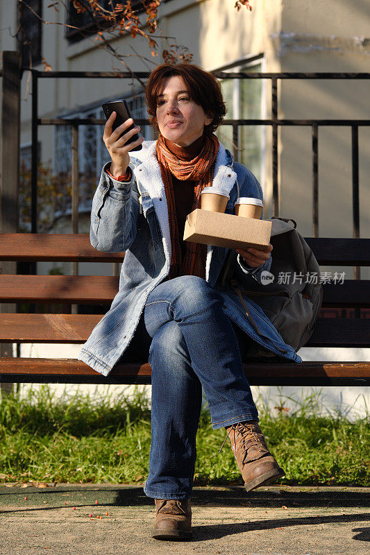 成熟的女人会在公园的长椅上等人