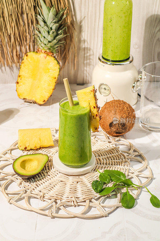 健康的绿色果汁饮料，含有鳄梨，菠萝，椰子和菠菜