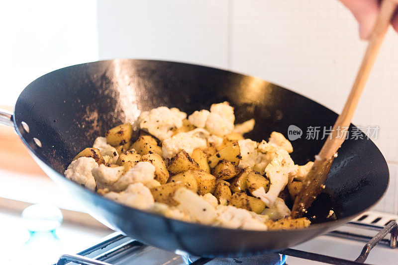 传统的印度食物与炒花椰菜，土豆和香料在锅中炖