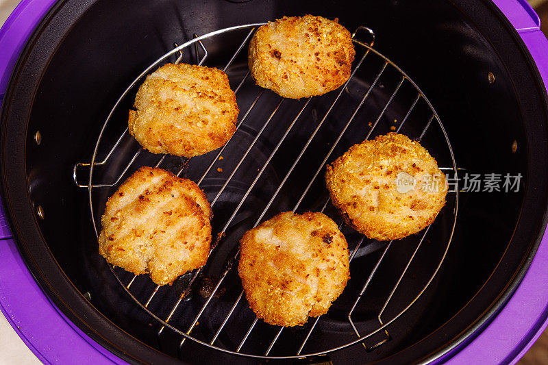 将煮熟的鸡肉丸放在钢格栅上，放入打开的空气炸锅中