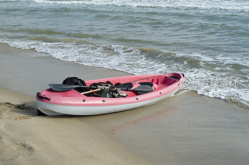 阳光灿烂的日子里，海滩上的红白双人皮艇