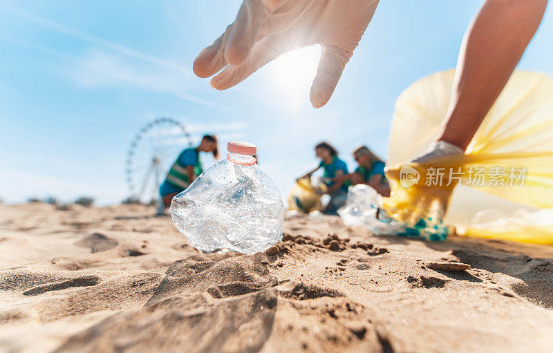 沙滩上捡拾塑料垃圾的生态志愿者团体——捡拾垃圾的积极分子保护地球——海洋污染、环境保护和生态理念