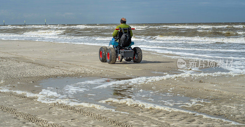 轮椅上的老人在德国北海地区的海滩上