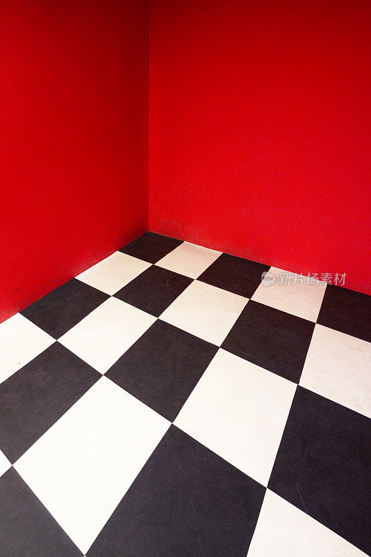 房间空荡荡，地板呈方格状，墙壁刷成红色。