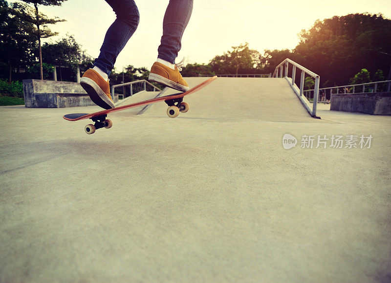 年轻的亚洲女子腿滑板在滑板公园