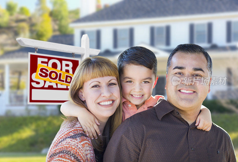 年轻的家庭在出售的房地产标志房子前