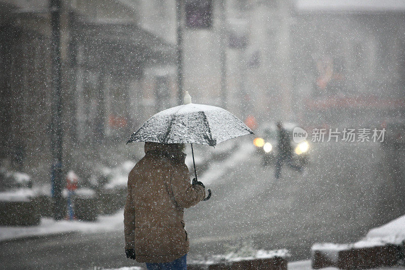 在暴风雪中打着伞的人