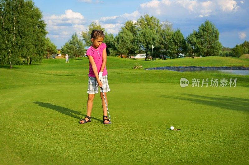 高尔夫球，女高尔夫球手把球打进洞里