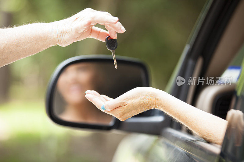 新车。售货员将车钥匙交给女买家、司机。