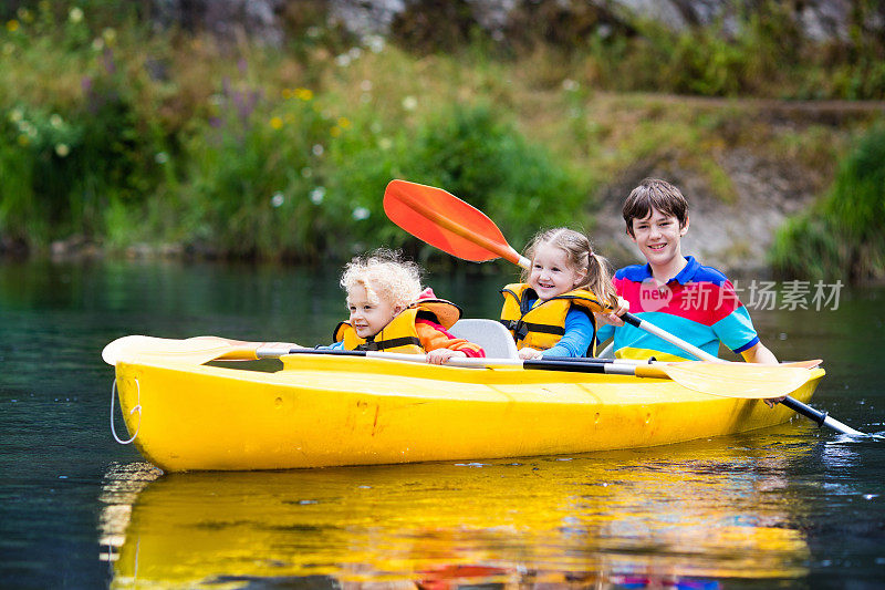 幸福的家庭和三个孩子在河上划皮划艇