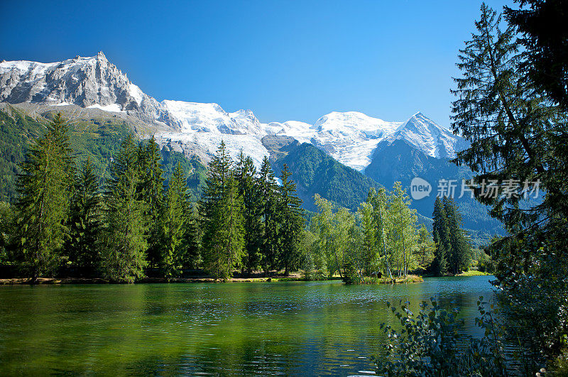 风景如画的高山湖在夏天与法国阿尔卑斯山的背景