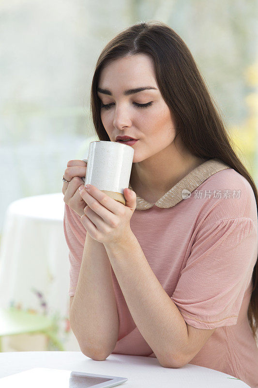 坐在咖啡馆里的年轻女子