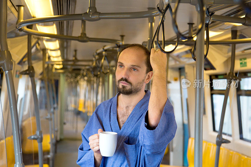 昏昏欲睡的男人在地铁里喝着咖啡