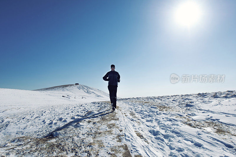 一名男子在冰冷的山上进行冬季跑步