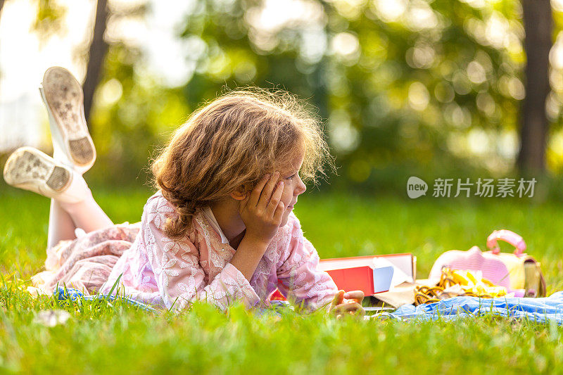 漂亮的小女孩在户外吃披萨