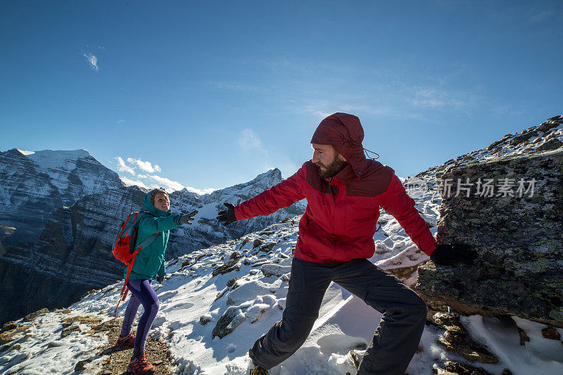 帮助同伴登山的徒步旅行者