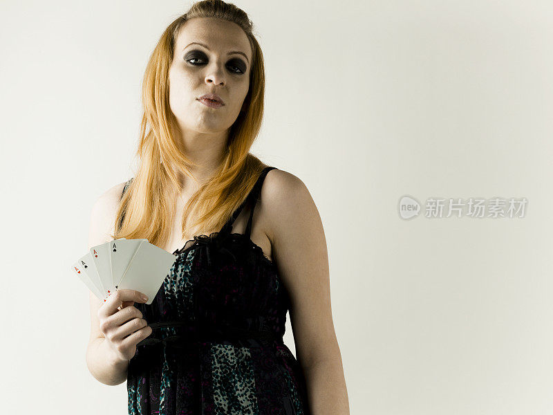 白色背景下手持扑克牌的妇女肖像