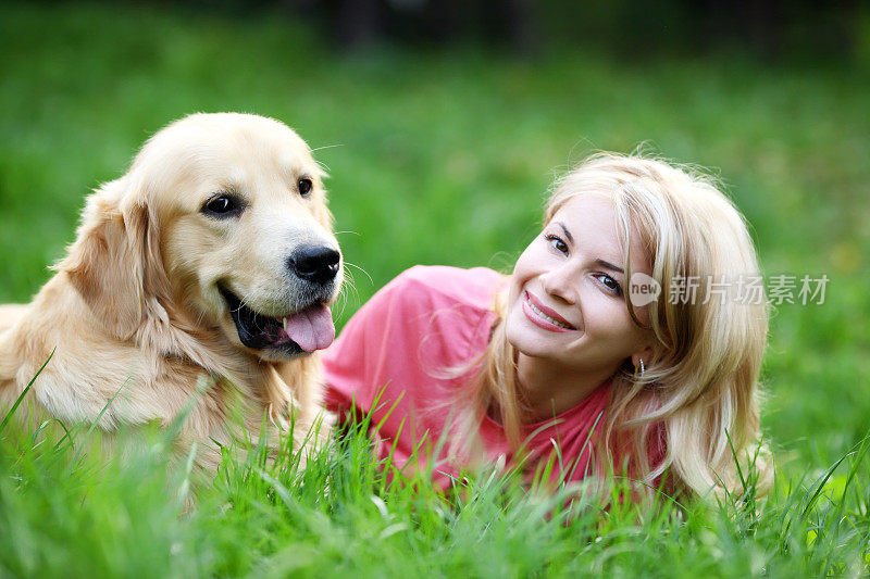 女孩和她美丽的金毛猎犬玩耍…