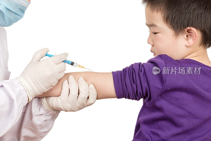 医生用针头给亚洲男孩接种疫苗