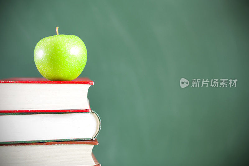 回到学校:绿苹果坐在教育课本上