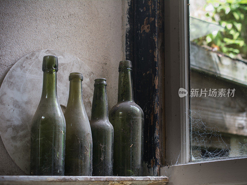 蛛网窗边的一排瓶子
