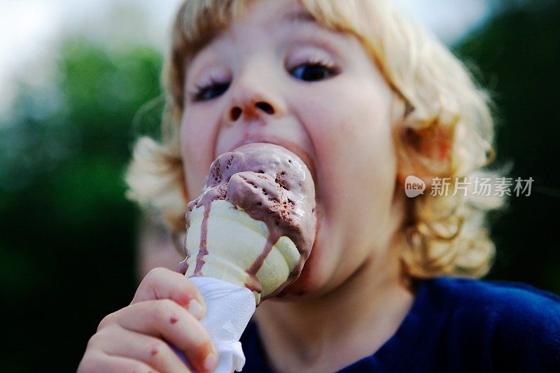 脏兮兮的小男孩在吃融化的冰淇淋蛋卷。
