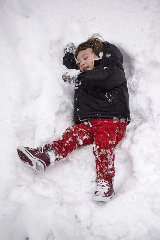 欢笑的宝宝在冬天的公园玩雪