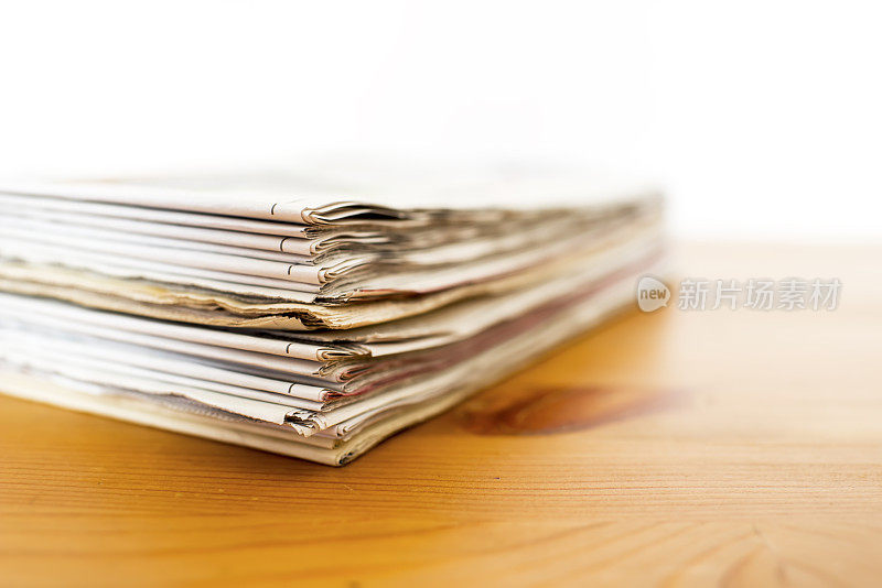 一堆孤立的报纸放在木桌上