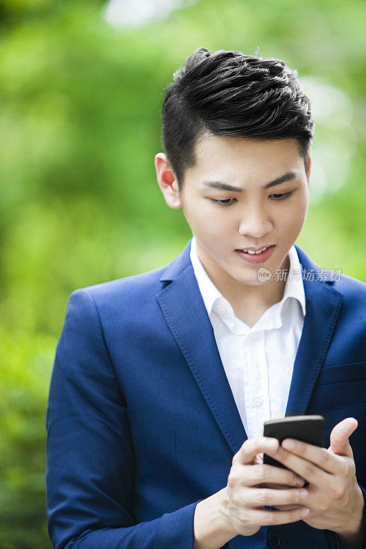 年轻的亚洲男子通过智能手机接收坏消息