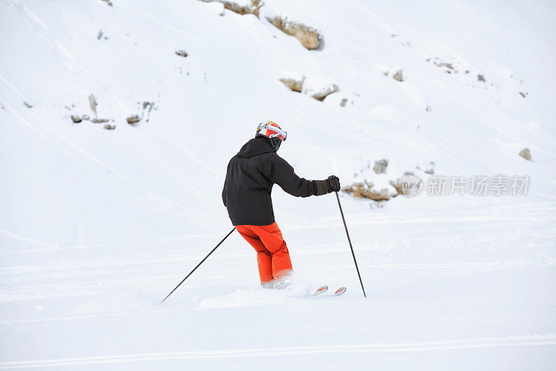 后视图男人在乡间滑雪，雪上有粉