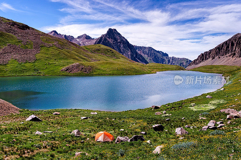 背包帐篷位置在风景秀丽的山与蓝色的湖