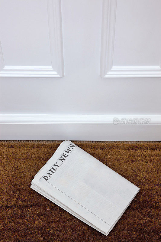 门前的垫子上放着一张空白的报纸。