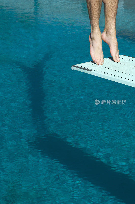 男子游泳运动员站在跳水板上