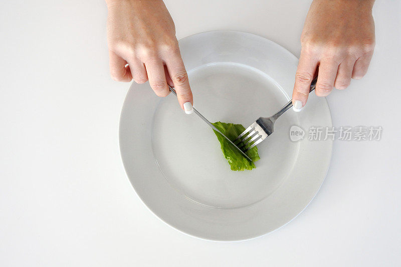 女人用手吃着一片生菜