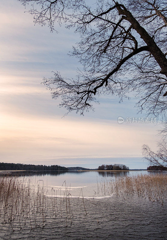 美丽而平静的夜晚与日落在冬天的湖泊，芬兰