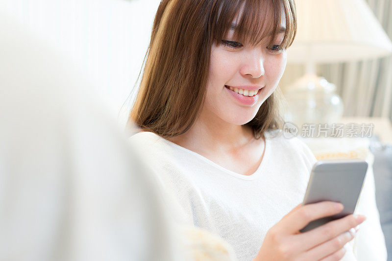 年轻美丽的亚洲女人与手机