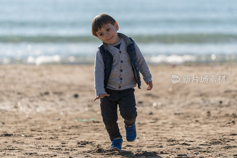 小男孩在海滩上跑步