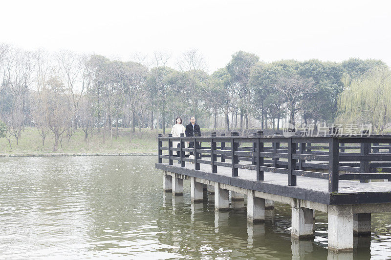 年轻男子和女子在人行桥上交谈