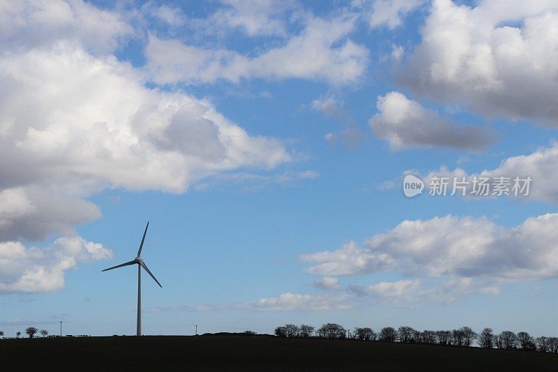 在乡村环境中，蓝天映衬着蓬松的白云，还有风力涡轮机或乡村公路