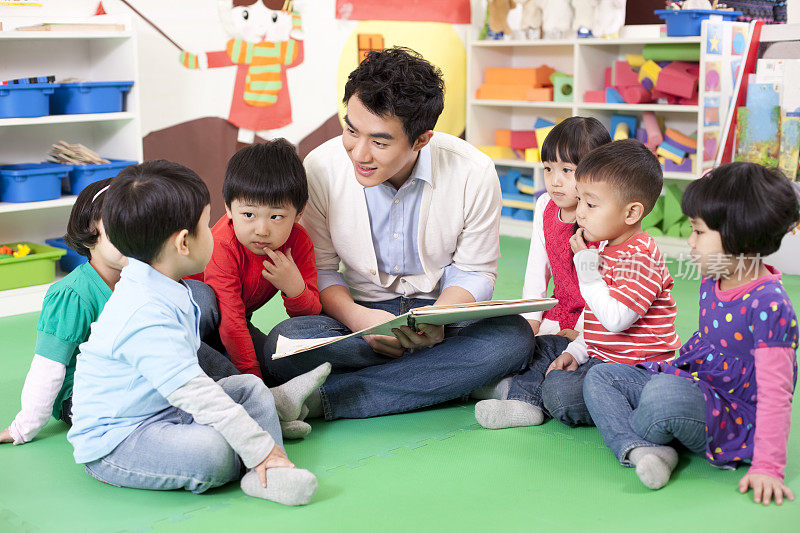 幼儿园老师和小朋友一起看图书