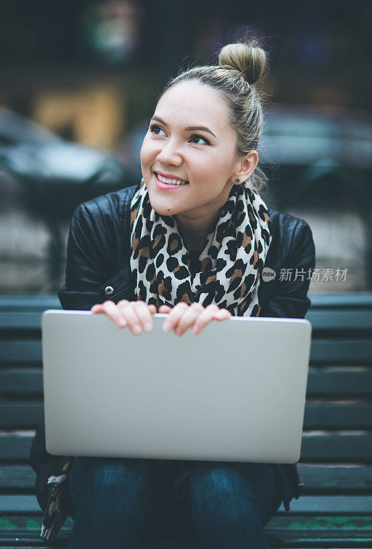 一个女人在街上用笔记本电脑