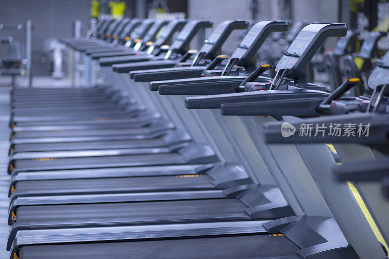 现代化的健身房内部配备设备。健身俱乐部配有一排排跑步机，提供健身有氧训练的健康生活理念