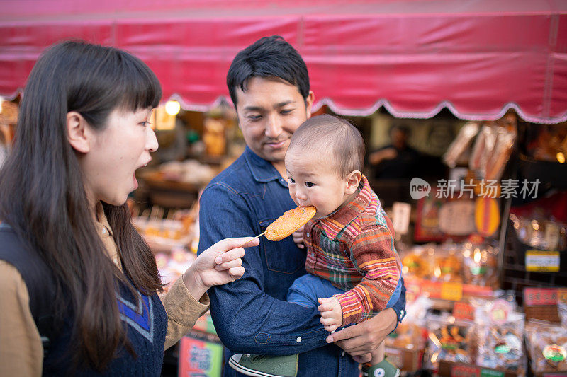 小男孩在街上吃着日本米饼